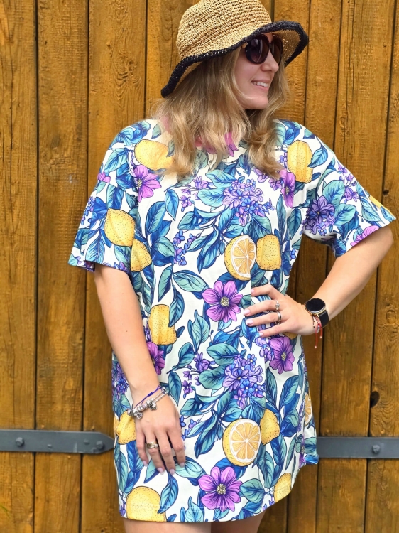 Sukienka oversize z jerseyu w cytryny i kwiaty na tle jasnej ściany