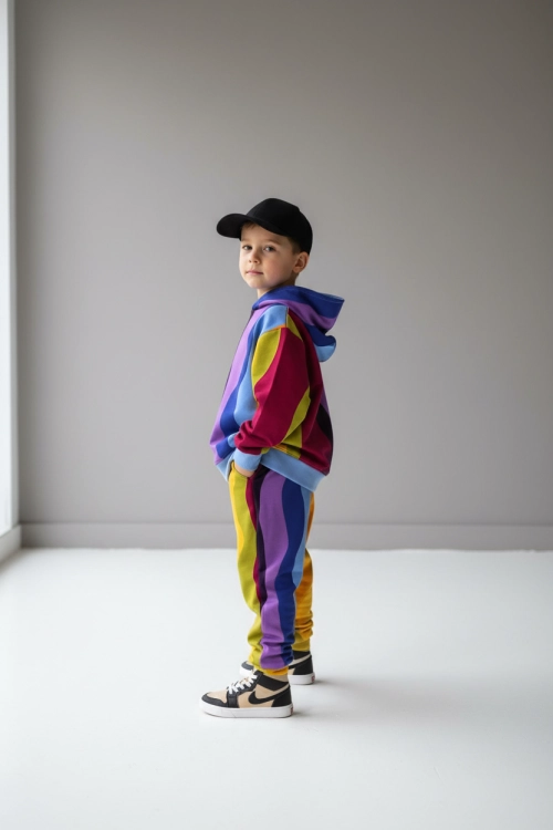 CHłopiec w kolorowym dresie bluza z kapturem i spodnie we wzór